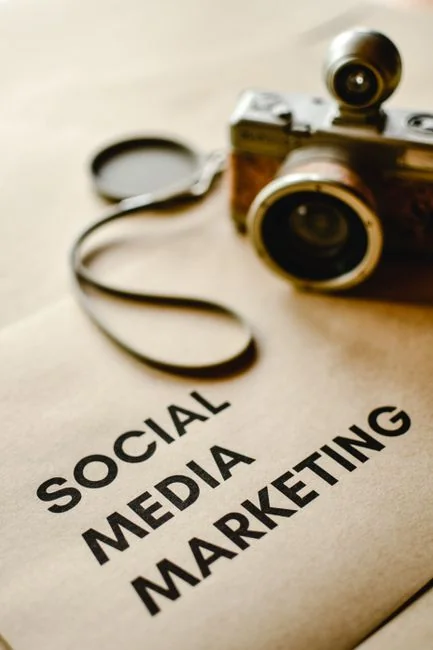 A desktop setup with social media marketing essentials including a keyboard, lightbox, and guide.